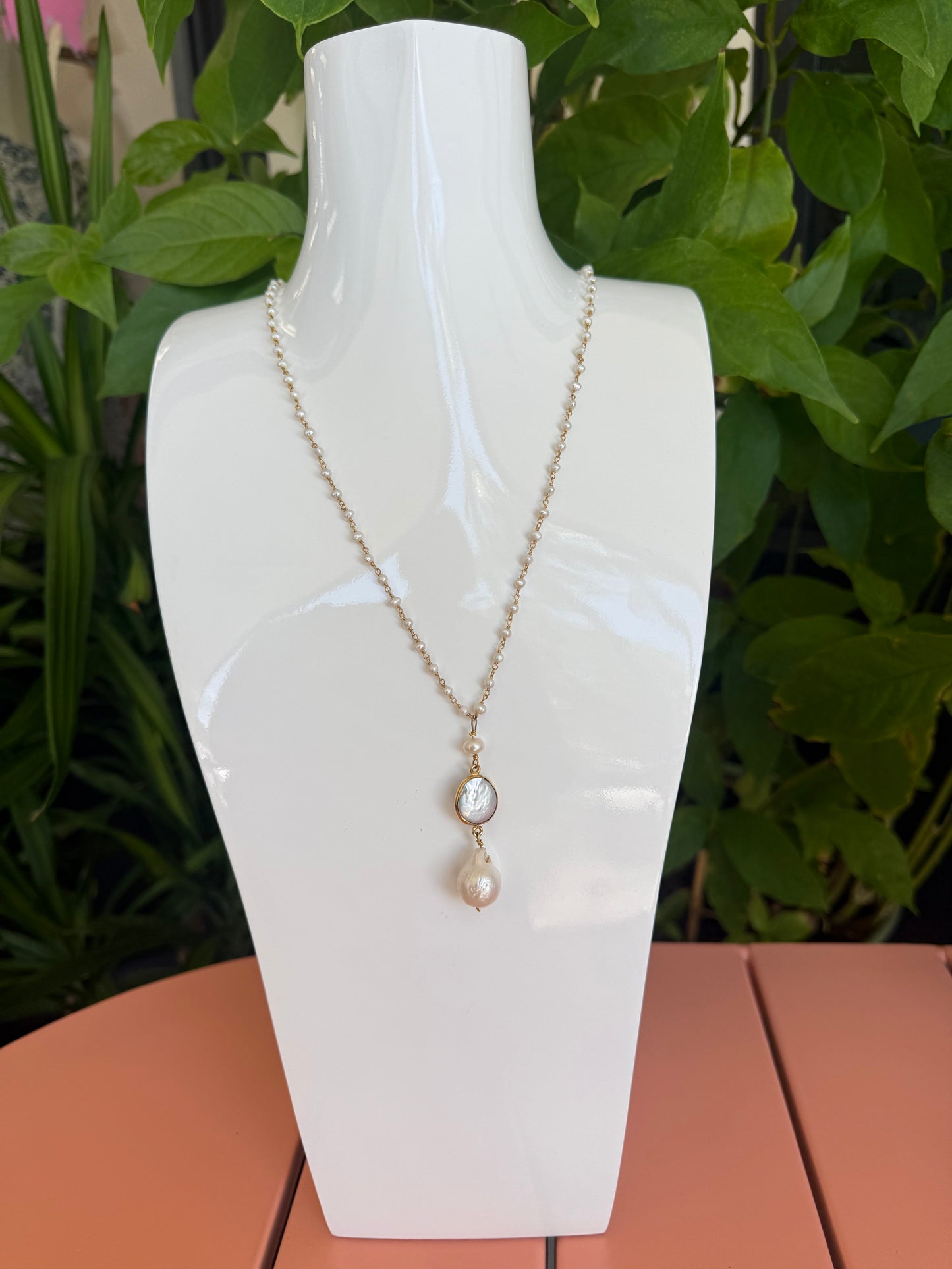 Necklace with two pearls on a white mannequin bust against a green leafy background. 17" Baby Pearl Necklace with a 2" Waterfresh pearl drop charm,