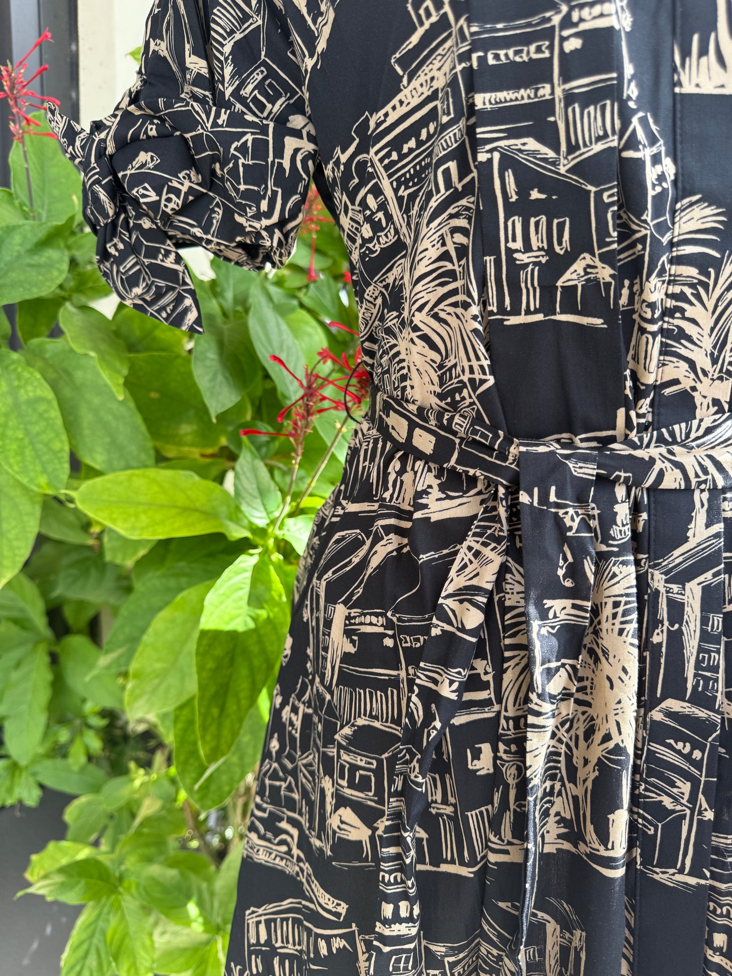 Close-up of a black and white patterned fabric with green plants in the background. Blue tracksuit on a mannequin with a decorative background. a staple for curated boutique fashion and chic affordable style available at your Womens Boutique West Palm Beach, FL.