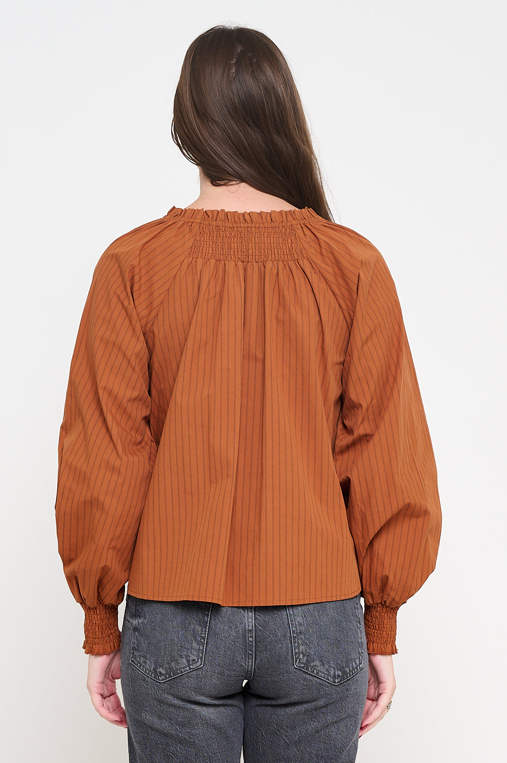 Person wearing a rust-colored blouse with long sleeves on a white background, Woman wearing a brown blouse with balloon sleeves on a white background,Kirstie Long Sleeve Terracotta Brown Blouse, a staple for curated boutique fashion and chic affordable style available at your Womens Boutique West Palm Beach, FL.