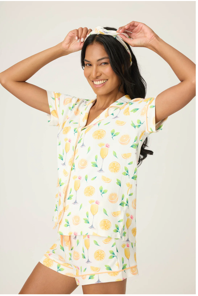 Woman wearing a lemon-patterned pajama set with a white background Set of pajama top, shorts, and headband with lemon pattern on a beige background
Maria Mimosa Me PJ Set, a staple for curated boutique fashion and chic affordable style available at your Womens Boutique West Palm Beach, FL.