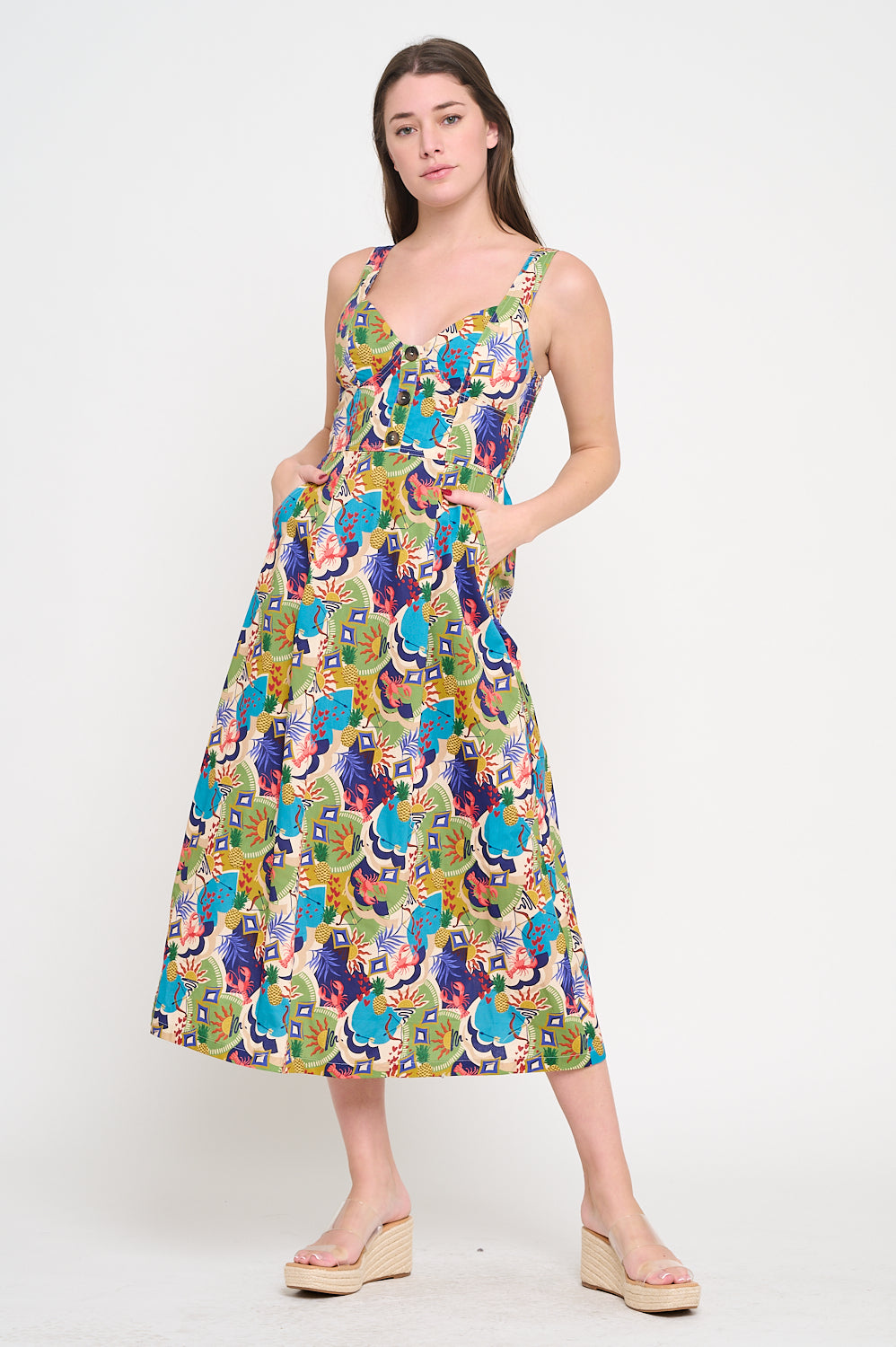 Woman wearing a colorful patterned dress on a white background. Raquel Midi Printed Dress a staple for curated boutique fashion and chic affordable style available at your Womens Boutique West Palm Beach, FL.
