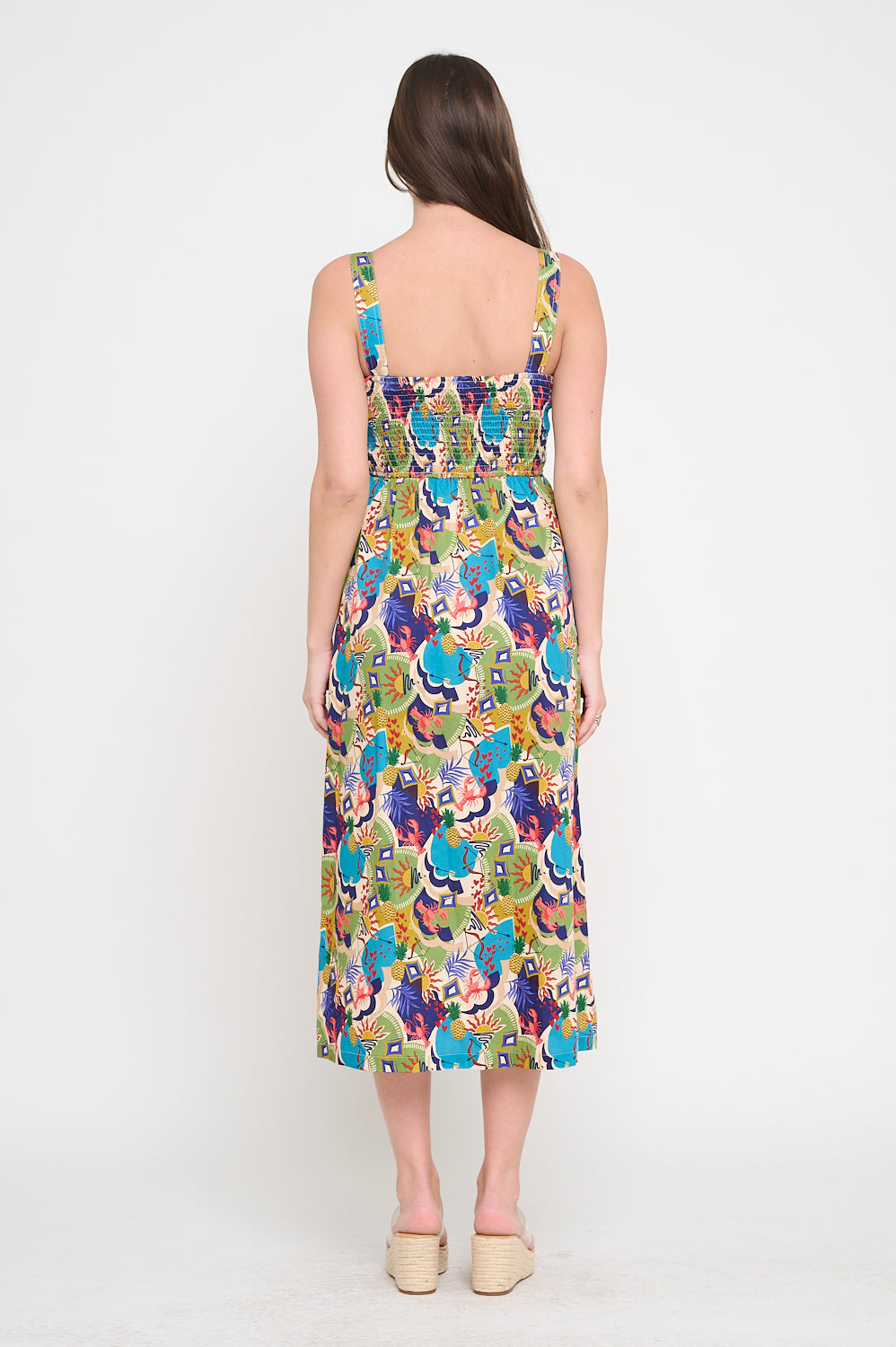 Woman wearing a colorful floral dress on a white background. Raquel Midi Printed Dress a staple for curated boutique fashion and chic affordable style available at your Womens Boutique West Palm Beach, FL.