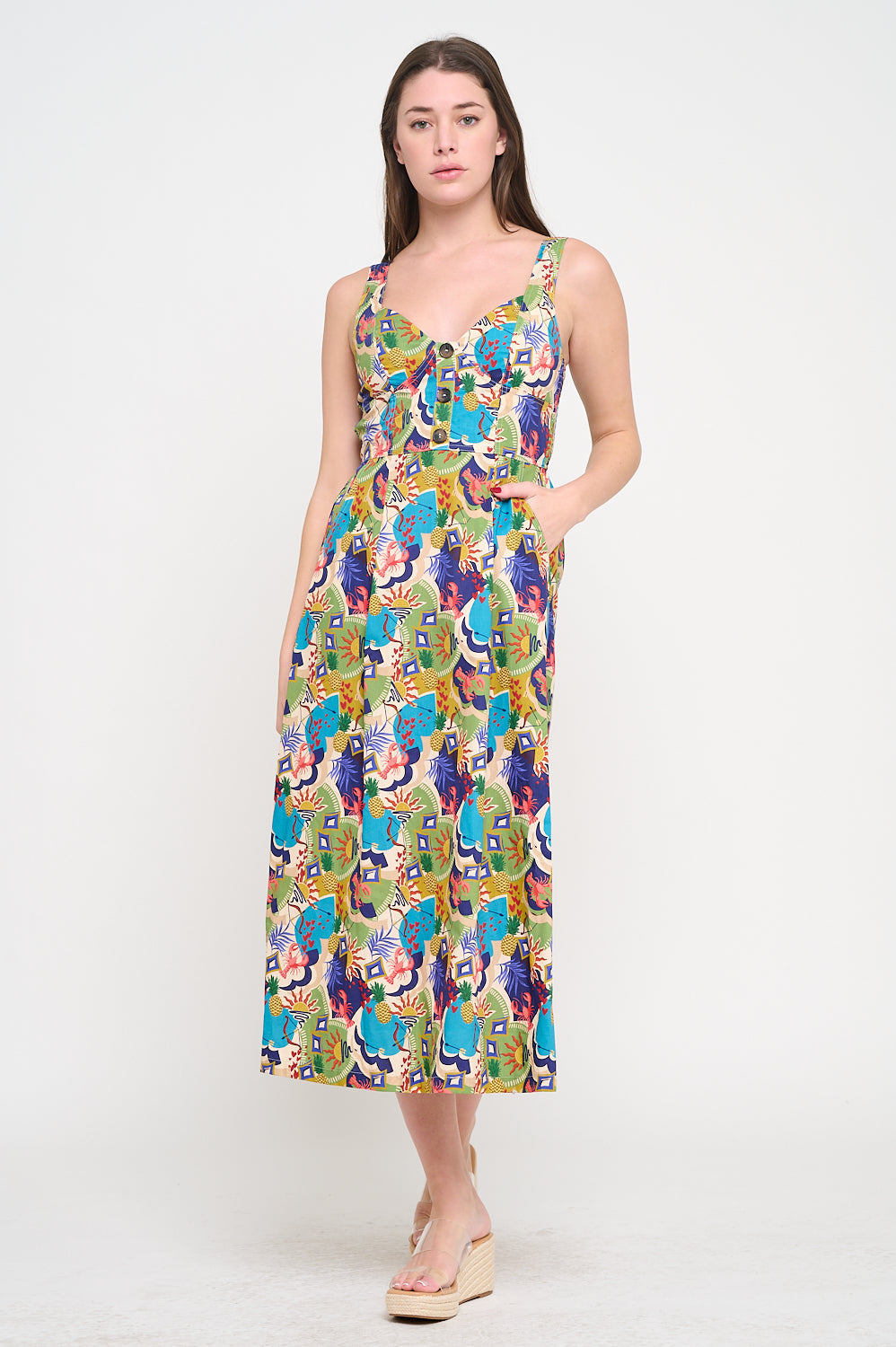 Woman wearing a colorful patterned dress on a white background. Raquel Midi Printed Dress a staple for curated boutique fashion and chic affordable style available at your Womens Boutique West Palm Beach, FL.