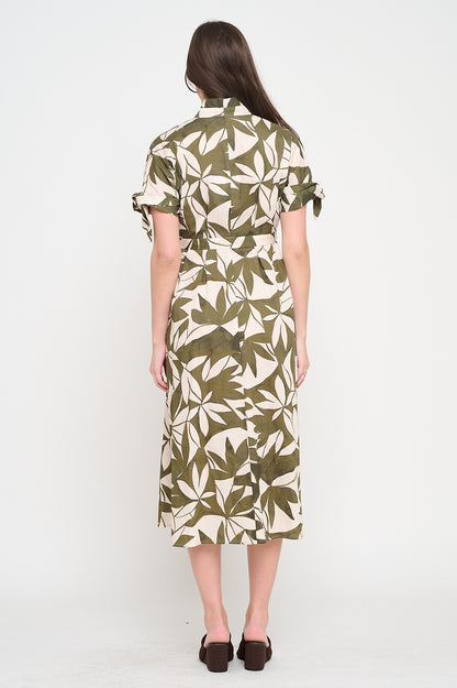 Woman wearing a green and white patterned dress on a white background, Woman wearing a green leaf-patterned dress on a white background, Bonnie Canopy Shirt Dress, a staple for curated boutique fashion and chic affordable style available at your Womens Boutique West Palm Beach, FL.