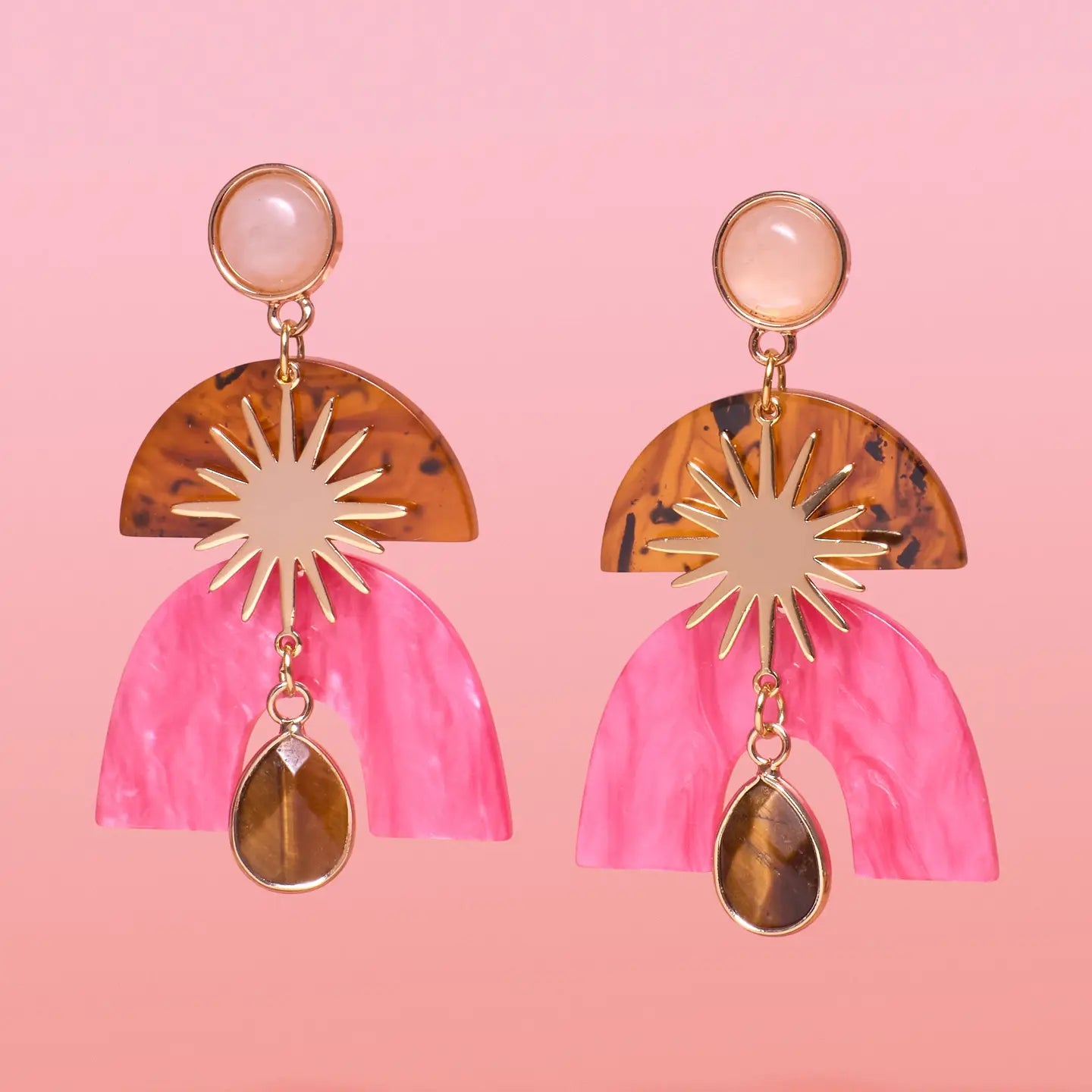 Pair of earrings with pink and tortoiseshell design on a pink background