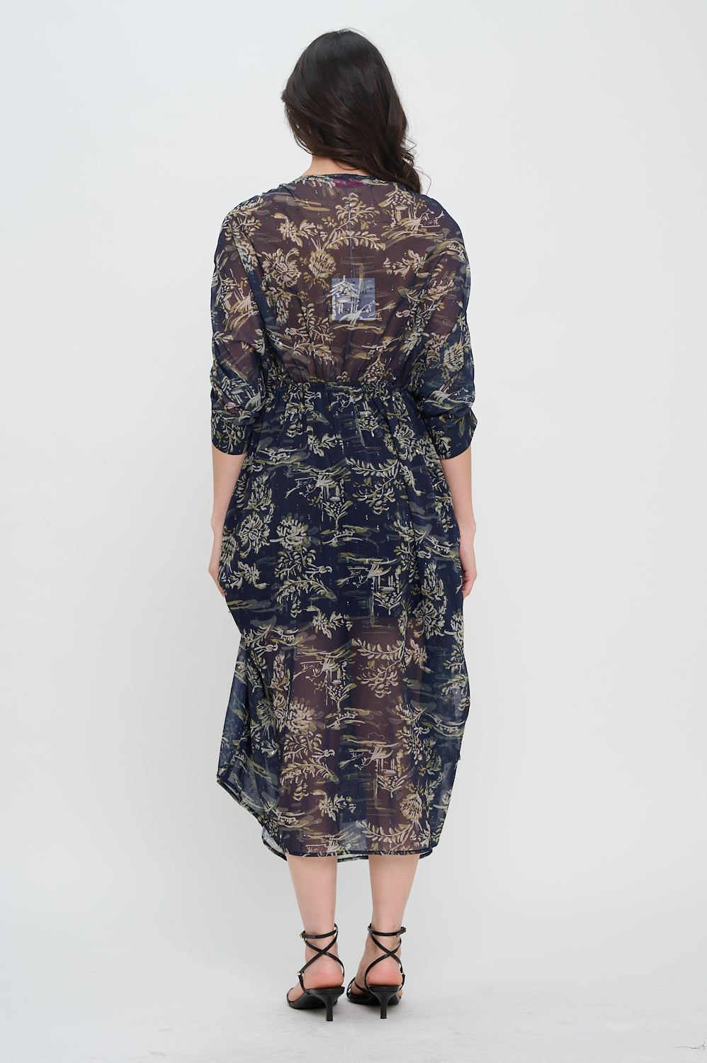 Woman wearing a floral dress with a plain white background. Capri Printed Midi Dress, a staple for curated boutique fashion and chic affordable style available at your Womens Boutique West Palm Beach, FL