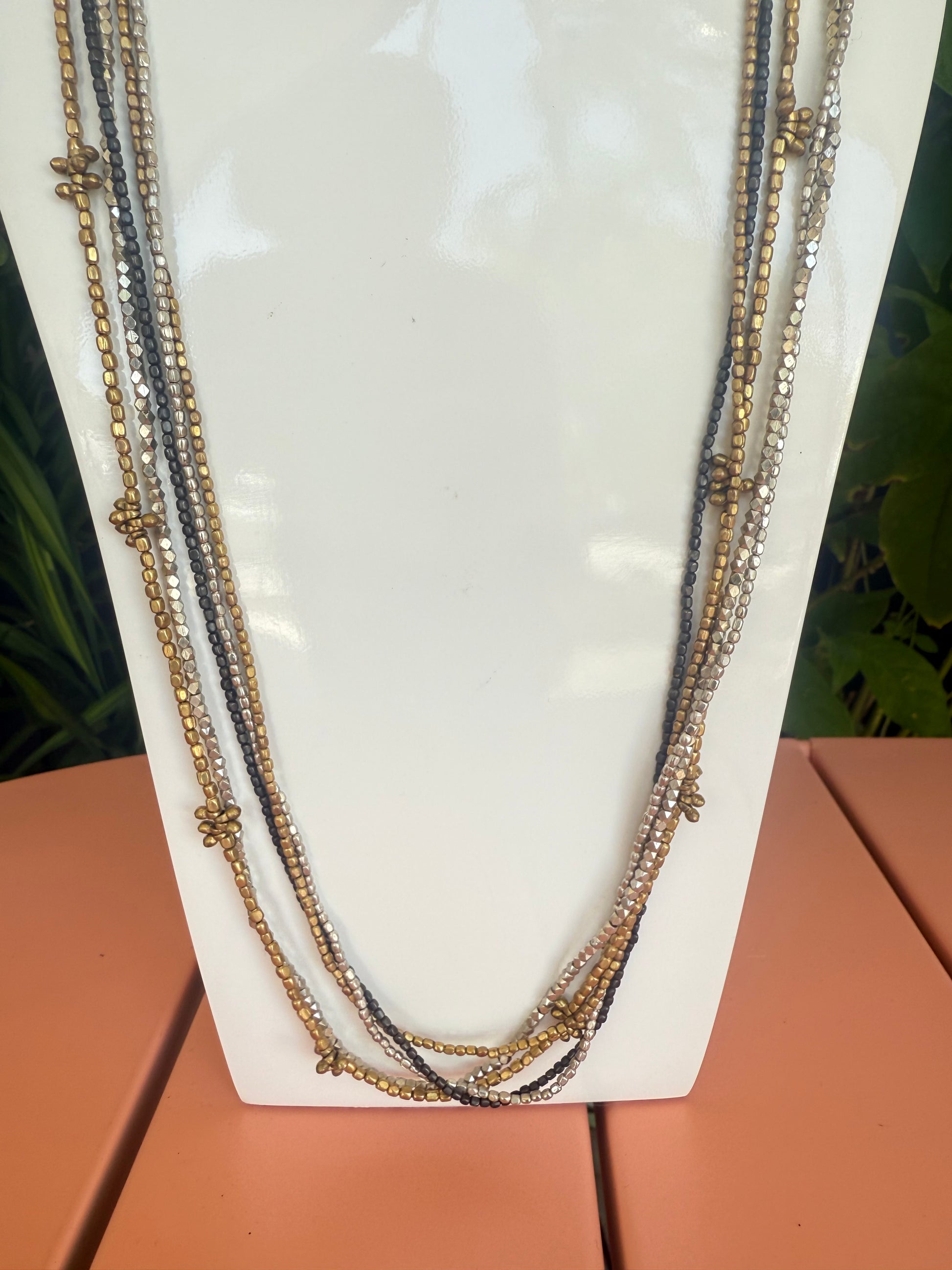 Necklace with multiple strands on a white surface. Cluster Silver, Metal. Dark Metal 17" long beaded necklace -