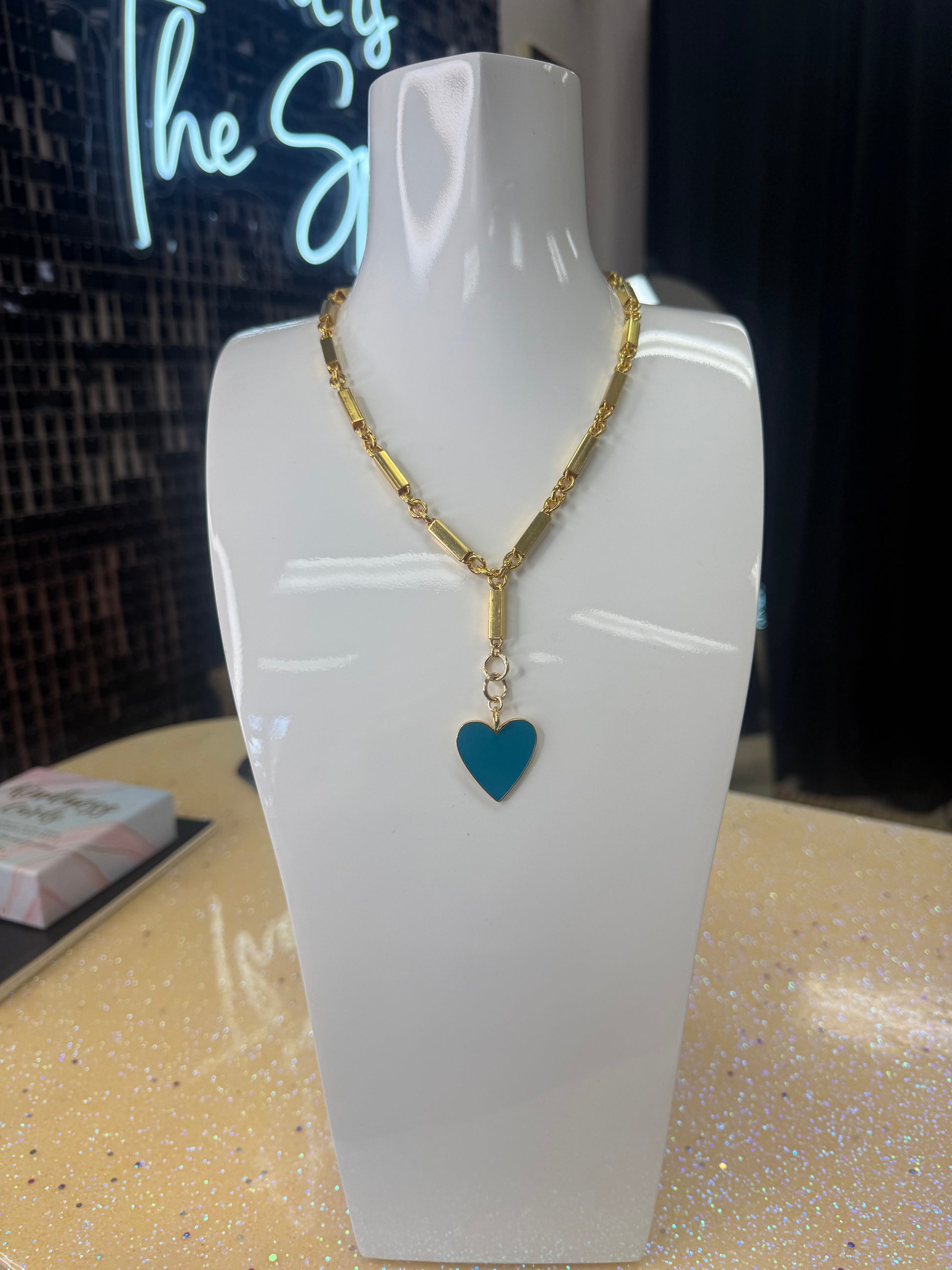 Add a splash of charm to your look with this playful Enamel Turquoise Heart pendant, hanging delicately from a gleaming gold chain. Its vibrant turquoise enamel brings a pop of color, while the heart shape adds a touch of whimsy and warmth. Perfect for brightening any outfit and sparking smiles wherever you go! A staple for curated boutique fashion and chic affordable style available at your Women's Boutique West Palm Beach, FL