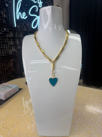 Add a splash of charm to your look with this playful Enamel Turquoise Heart pendant, hanging delicately from a gleaming gold chain. Its vibrant turquoise enamel brings a pop of color, while the heart shape adds a touch of whimsy and warmth. Perfect for brightening any outfit and sparking smiles wherever you go! A staple for curated boutique fashion and chic affordable style available at your Women's Boutique West Palm Beach, FL