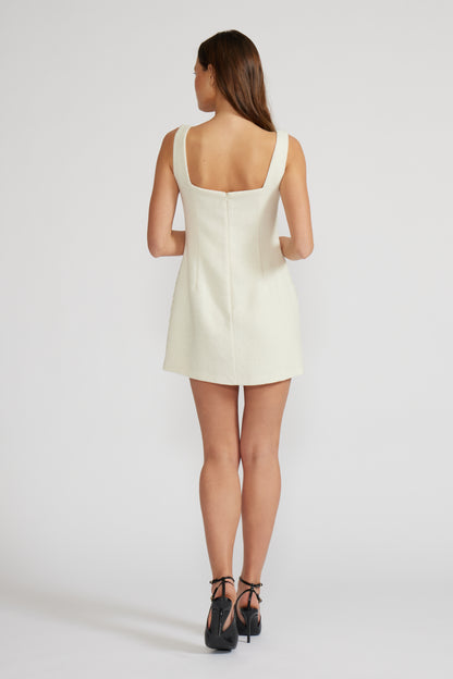 Woman wearing a white dress on a plain background,Woman wearing a white quilted dress on a white background.Gemma Embroidered Mini Dress.  a staple for curated boutique fashion and chic affordable style available at your Womens Boutique West Palm Beach, FL.