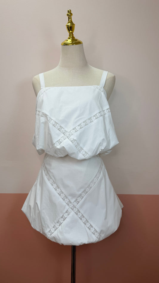 White lace top and skirt set on a mannequin against a plain background