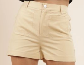 Beige shorts worn by a person on a beige background, Mel High Waisted Shorts, a staple for curated boutique fashion and chic affordable style available at your Womens Boutique West Palm Beach, FL.