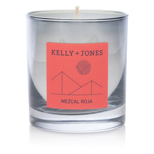 Clear glass candle with a red label featuring 'Kelly + Jones' and 'Mezcal Roja' on a white background. a staple for curated boutique fashion and chic affordable style available at your Womens Boutique West Palm Beach, FL.
