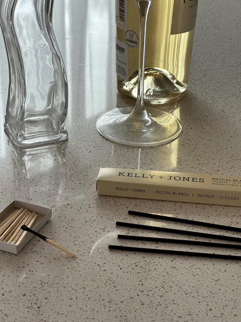 Matches, a matchbox, and a bottle of wine on a textured surface. a staple for curated boutique fashion and chic affordable style available at your Womens Boutique West Palm Beach, FL.
