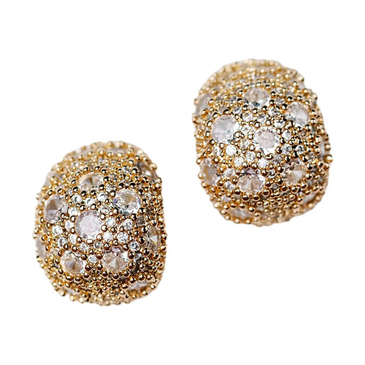 Gold spherical earrings with clear gemstones on a white background