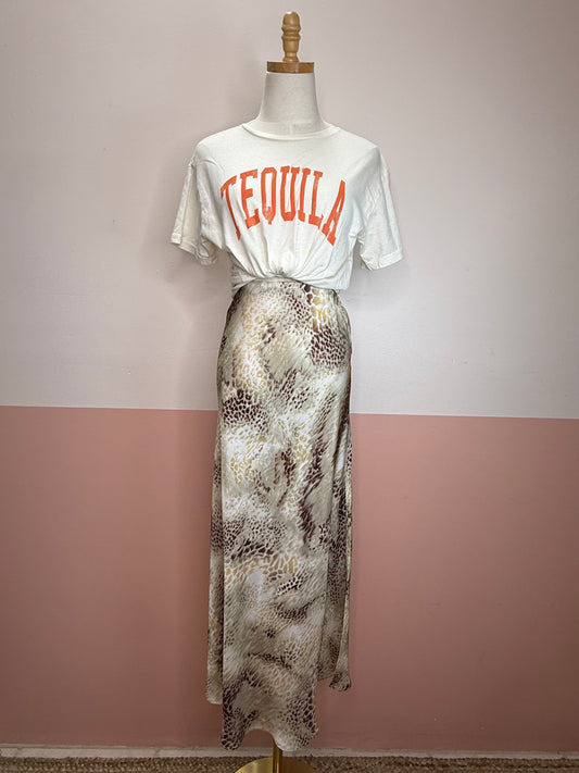 Mannequin wearing a white t-shirt with 'TEQUILA' text and a patterned skirt against a two-tone wall.