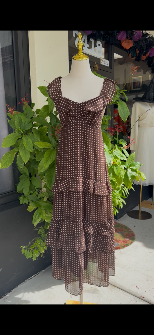 Mannequin wearing a brown patterned dress in a store setting with plants and furniture.Blue tracksuit on a mannequin with a decorative background. a staple for curated boutique fashion and chic affordable style available at your Womens Boutique West Palm Beach, FL.
