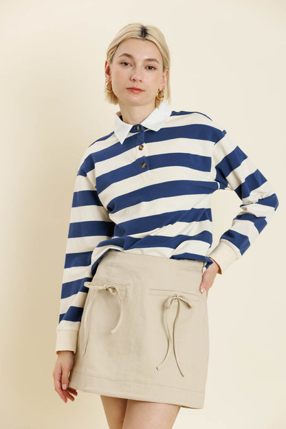 Person wearing a blue and white striped sweater with a beige skirt on a plain background. Yara Striped L/S Shirt, a staple for curated boutique fashion and chic affordable style available at your Womens Boutique West Palm Beach, FL.
